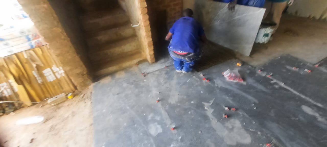 Worker preparing subfloor for tiling
